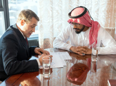 Two male delegates sitting at a table at working meeting
